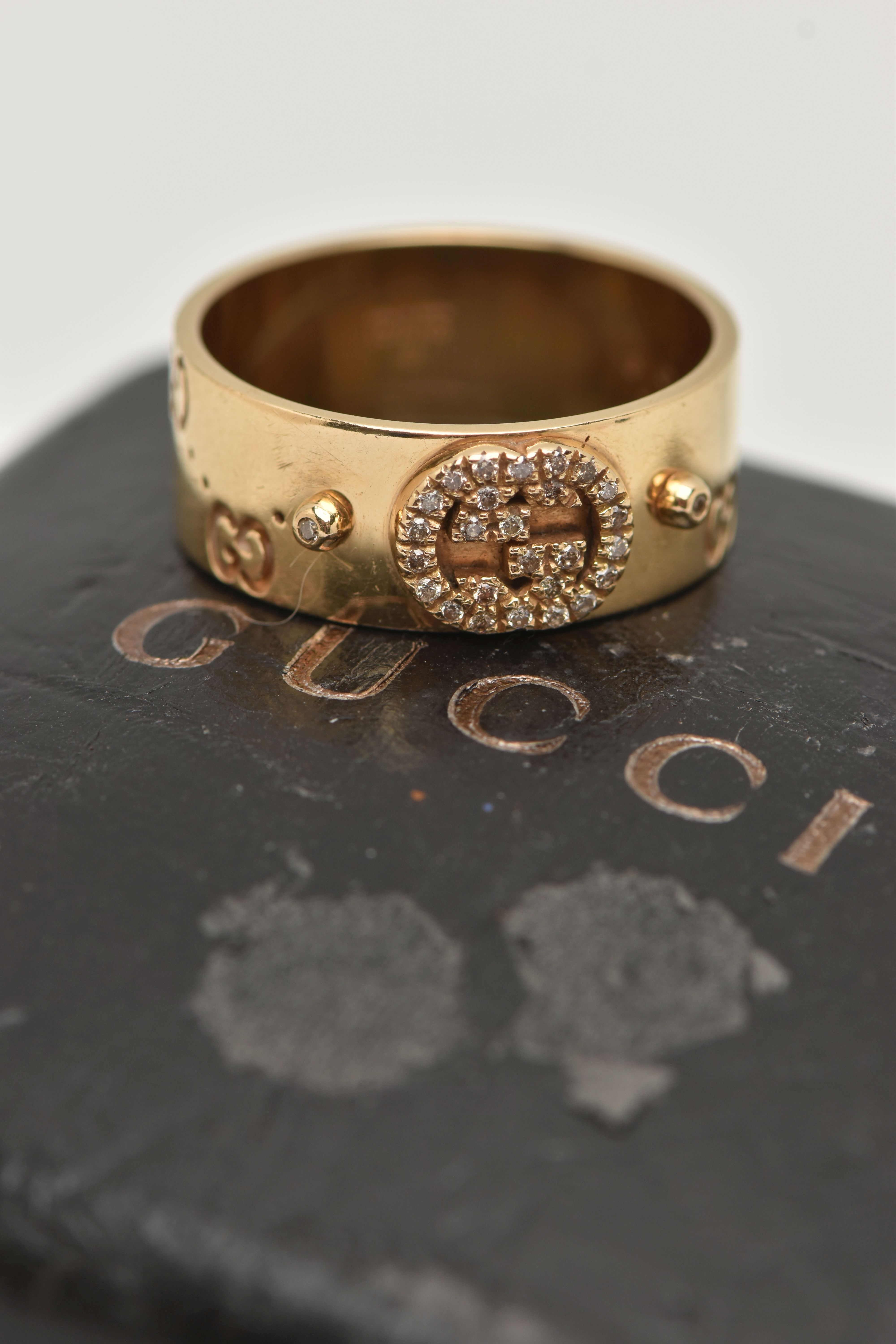 AN 18CT GOLD 'GUCCI' ICON BAND RING, a wide yellow metal band with a repetitive 'Gucci' logo and a - Image 5 of 5