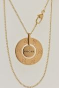 A 'GUCCI' ICON NECKLACE, a yellow metal circular disk pendant with a moveable central disk,