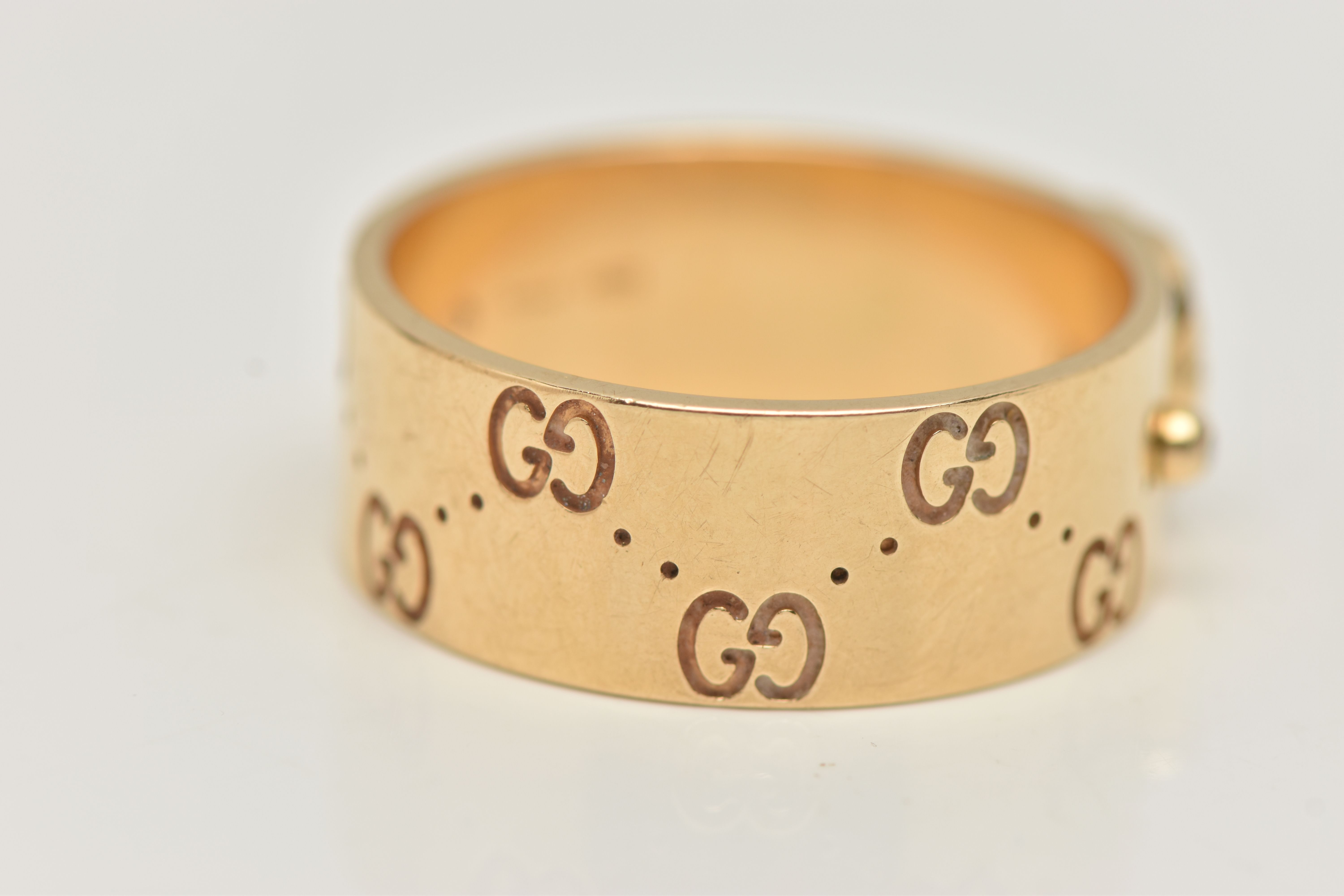 AN 18CT GOLD 'GUCCI' ICON BAND RING, a wide yellow metal band with a repetitive 'Gucci' logo and a - Image 3 of 5