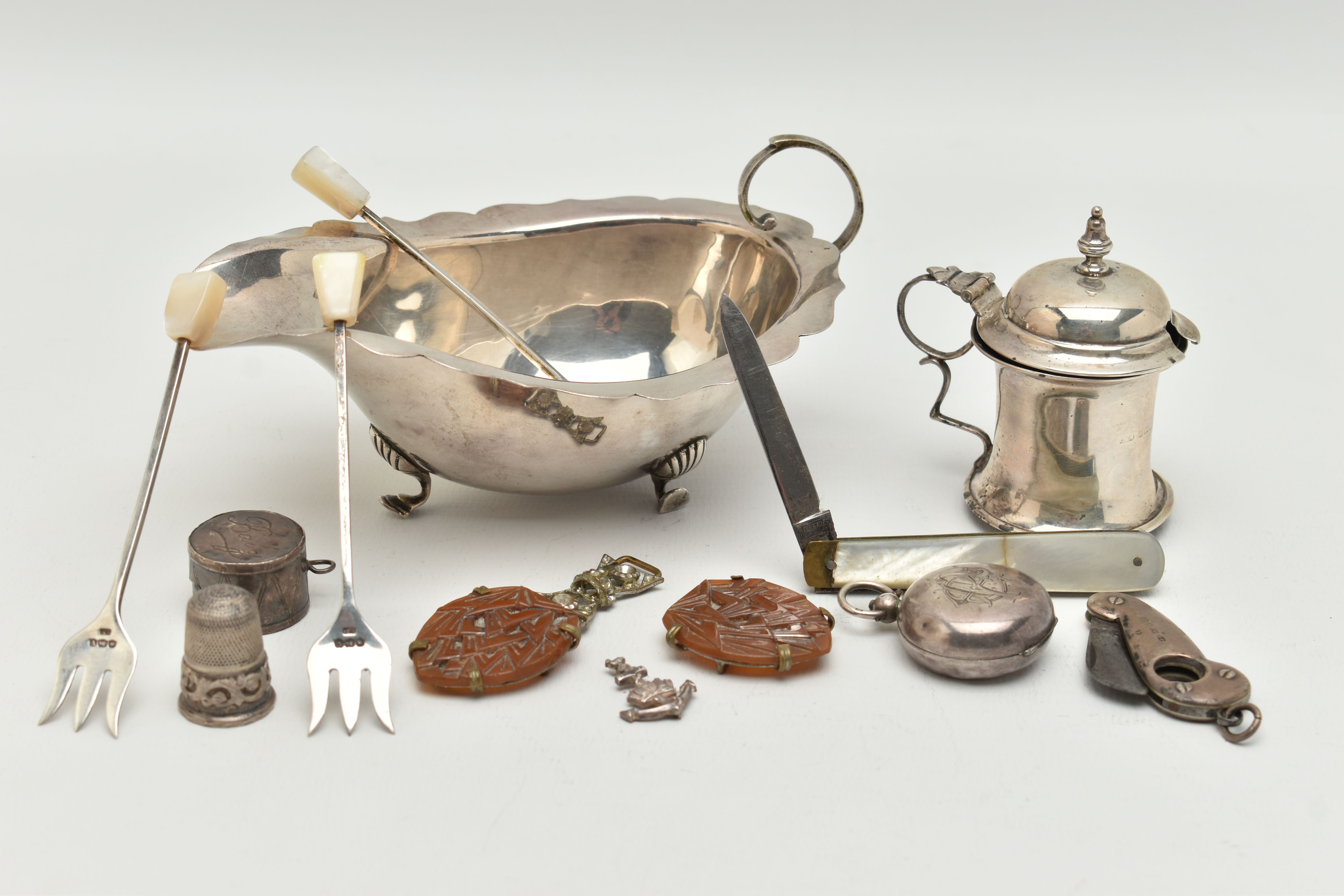 A SELECTION OF SILVER ITEMS, to include a gravy boat, with wavy rim, raised on three cabriole legs