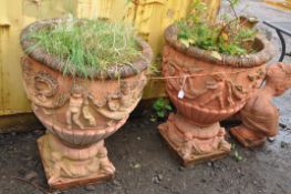 A PAIR OF LARGE MODERN COMPOSITE GARDEN URNS, terracotta painted, with Cherubs holding garlands of