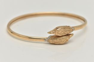 AN EAGLE HEAD CROSSOVER BANGLE, the bangle of crossover slightly sprung design with an eagle head to