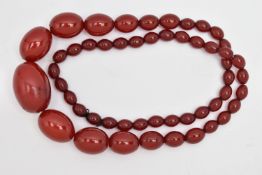 A BAKELITE CHERRY AMBER BEAD NECKLACE, a single strand of oval beads, largest bead measures