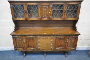 A REPRODUCTION WEBBER OAK TRESTLE DRESSER, top with lead glazed doors, atop a base with four drawers