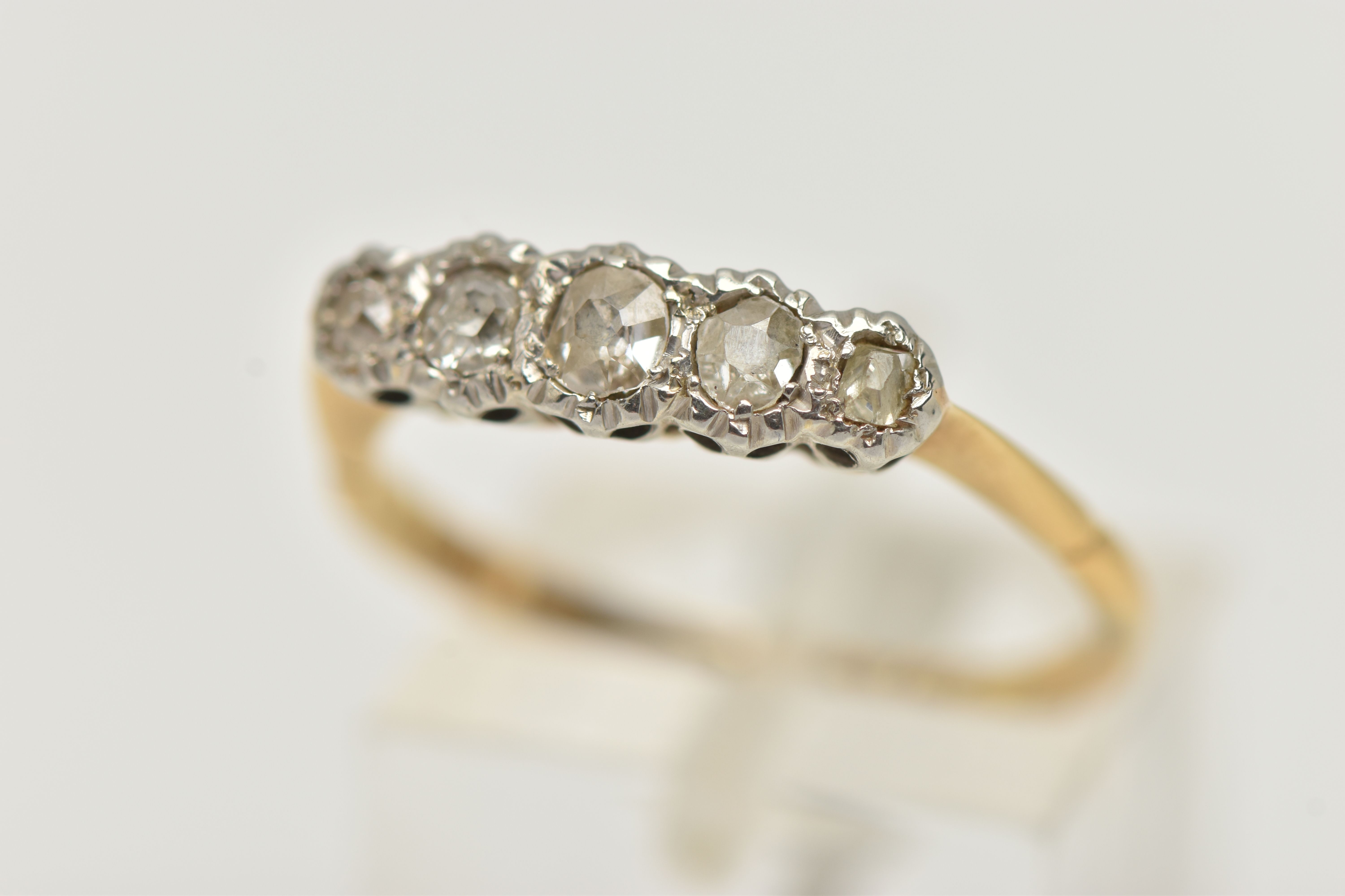 A YELLOW AND WHITE METAL DIAMOND FIVE STONE RING, set with five graduated old cut diamonds,