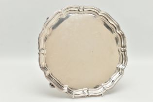 A GEORGE V SILVER PRESENTATION SALVER, of a circular form with wavy rim, raised on four scroll feet,