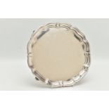 A GEORGE V SILVER PRESENTATION SALVER, of a circular form with wavy rim, raised on four scroll feet,