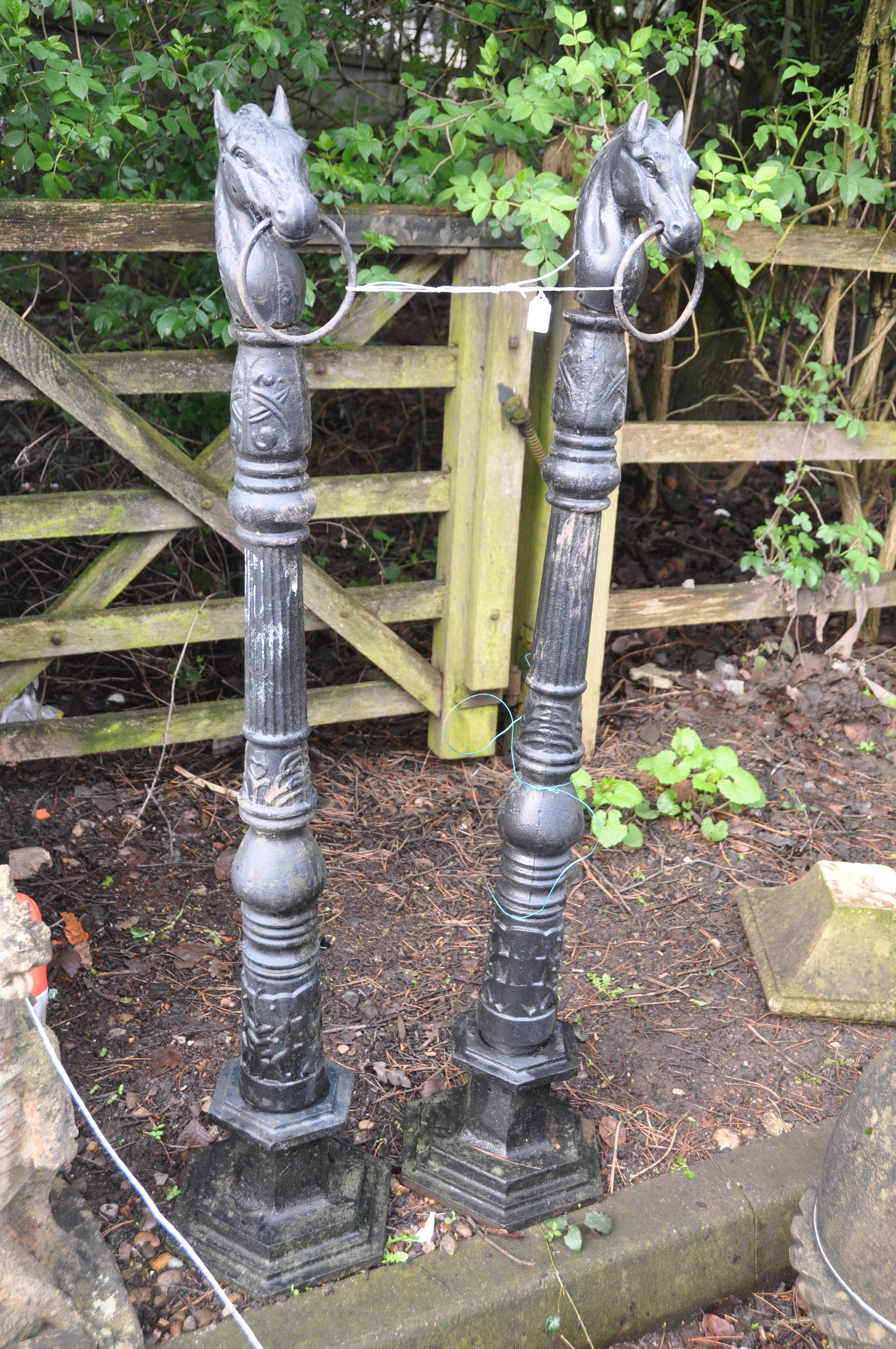A PAIR OF PAINTED CAST IRON POSTS with what appears to be Celtic detailing, horses heads loose at