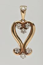 A 9CT GOLD AND DIAMOND PENDANT, designed as an open work heart with scrolling detail, set with seven