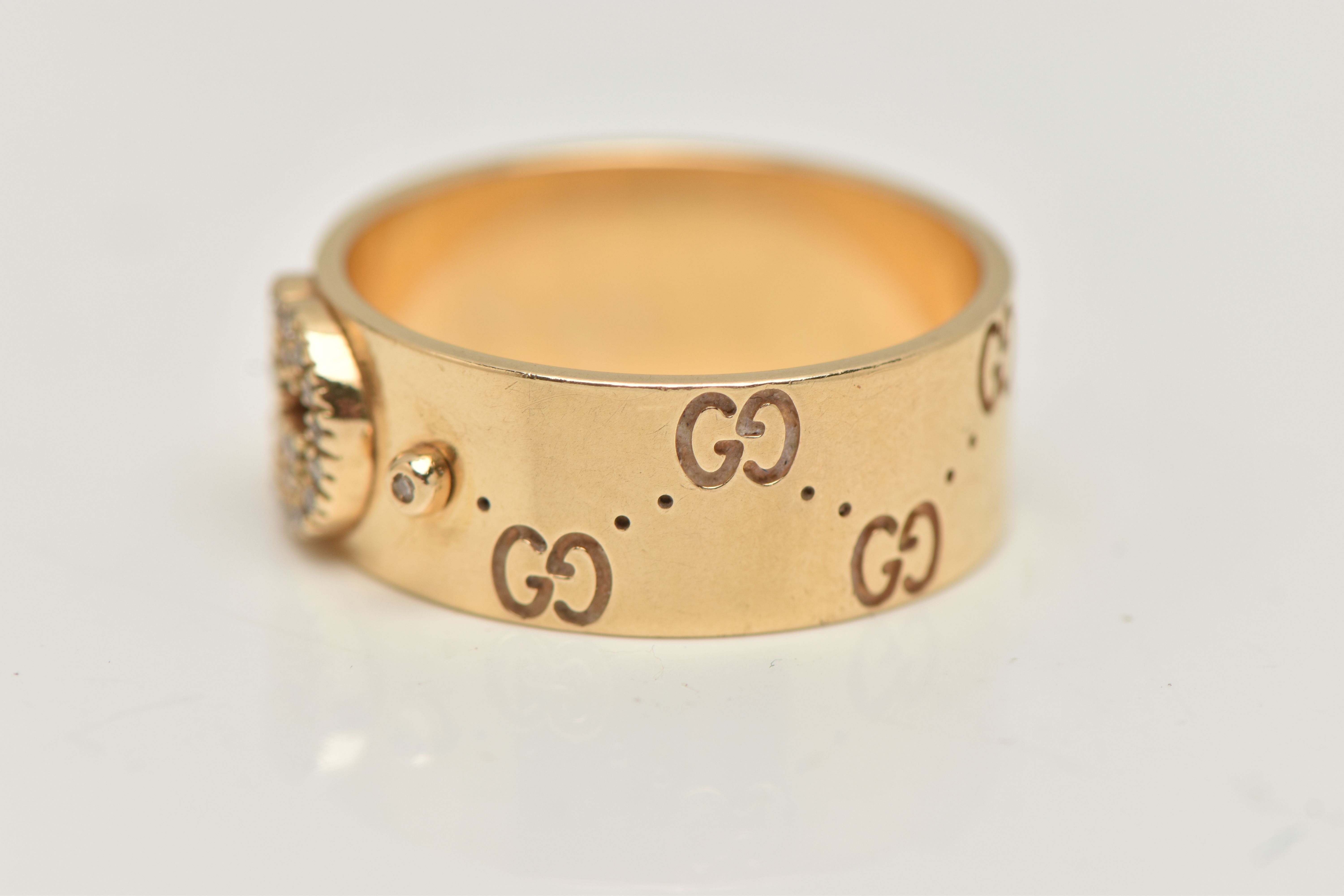 AN 18CT GOLD 'GUCCI' ICON BAND RING, a wide yellow metal band with a repetitive 'Gucci' logo and a - Image 2 of 5