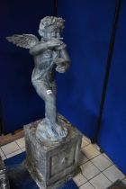 A SECOND HALF 20TH CENTURY WEATHERED BRONZE FIGURE OF CHERUB POSED HOLDING CHIMES, on a naturalistic