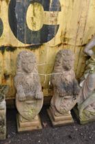 A PAIR OF WEATHERED COMPOSITE GARDEN FIGURES in the form of lion standing on their back legs holding