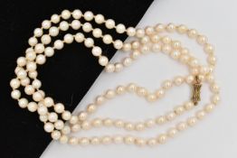 A LONG CULTURED PEARL NECKLACE, the uniform necklace with pinch waist, gold plated, push piece