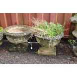 A PAIR OF WEATHERED COMPOSITE CIRCULAR GARDEN PLANTERS with foliate detail and a square foot 49cm in