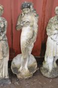 A WEATHERED COMPOSITE GARDEN FIGURE OF A CLAD LADY STANDING IN A SHELL, height 119cm (Condition