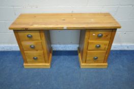 A MODERN PINE DESK, fitted with six drawers, length 135cm x depth 45cm x height 75cm (condition