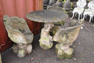 A WEATHERED COMPOSITE GARDEN TABLE AND THREE SIMILAR CHAIRS, the table is in the form of a crouching