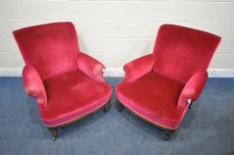 A PAIR OF EARLY 20TH CENTURY ARMCHAIRS, with maroon upholstery, on turned front legs and brass
