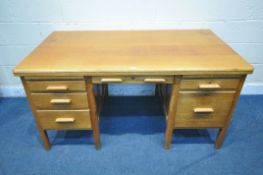 A 20TH CENTURY OAK DESK, fitted with five drawers and two brushing slides, length 152cm x depth 85cm