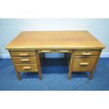 A 20TH CENTURY OAK DESK, fitted with five drawers and two brushing slides, length 152cm x depth 85cm