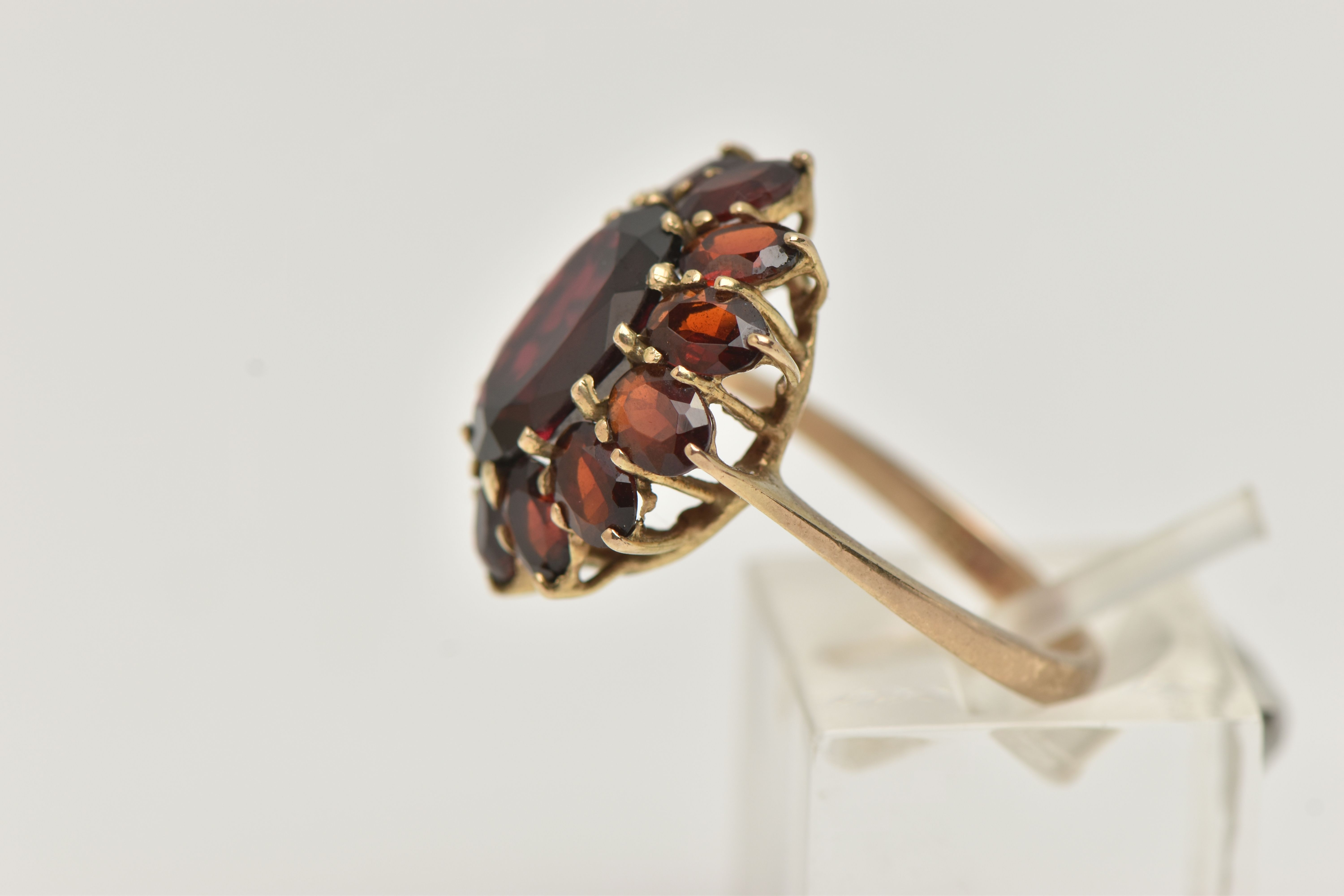 A GARNET CLUSTER RING, designed as a central oval garnet within an oval garnet surround, in claw - Image 2 of 4