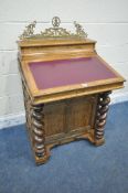 A 20TH CENTURY OAK DAVENPORT, the raised pen tidy compartment with a later added decorative brass