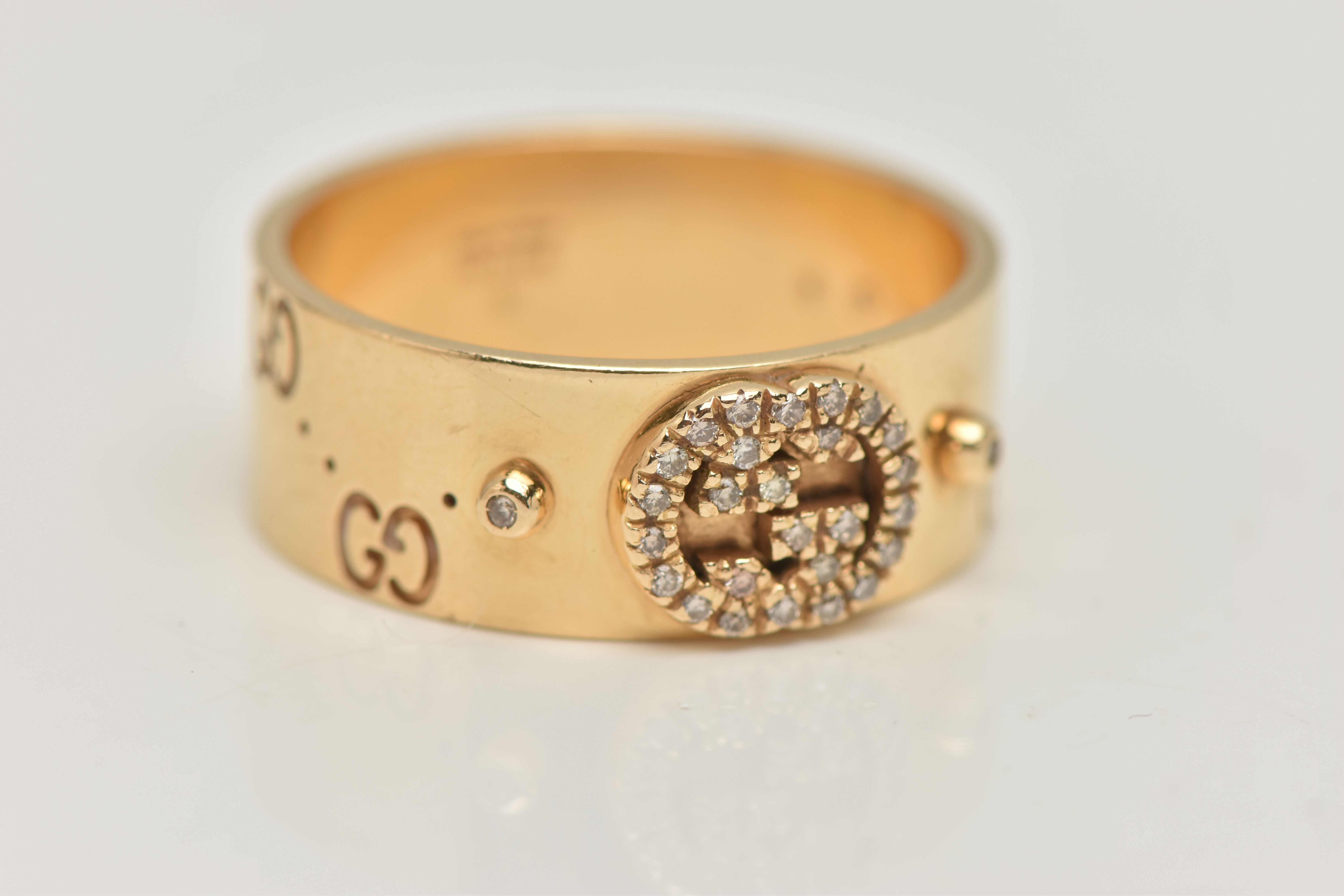 AN 18CT GOLD 'GUCCI' ICON BAND RING, a wide yellow metal band with a repetitive 'Gucci' logo and a - Image 4 of 5