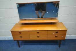 A MID CENTURY TEAK DRESSING TABLE, with a rectangular mirror, a raised shelf, fitted with six