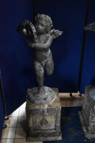 A SECOND HALF 20TH CENTURY WEATHERED BRONZE FIGURE OF CHERUB POSED HOLDING A TAMBOURINE, on a