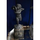 A SECOND HALF 20TH CENTURY WEATHERED BRONZE FIGURE OF CHERUB POSED HOLDING A TAMBOURINE, on a