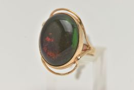 A TREATED OPAL RING, the oval opal cabochon in a collet setting to the bifurcated shoulders and