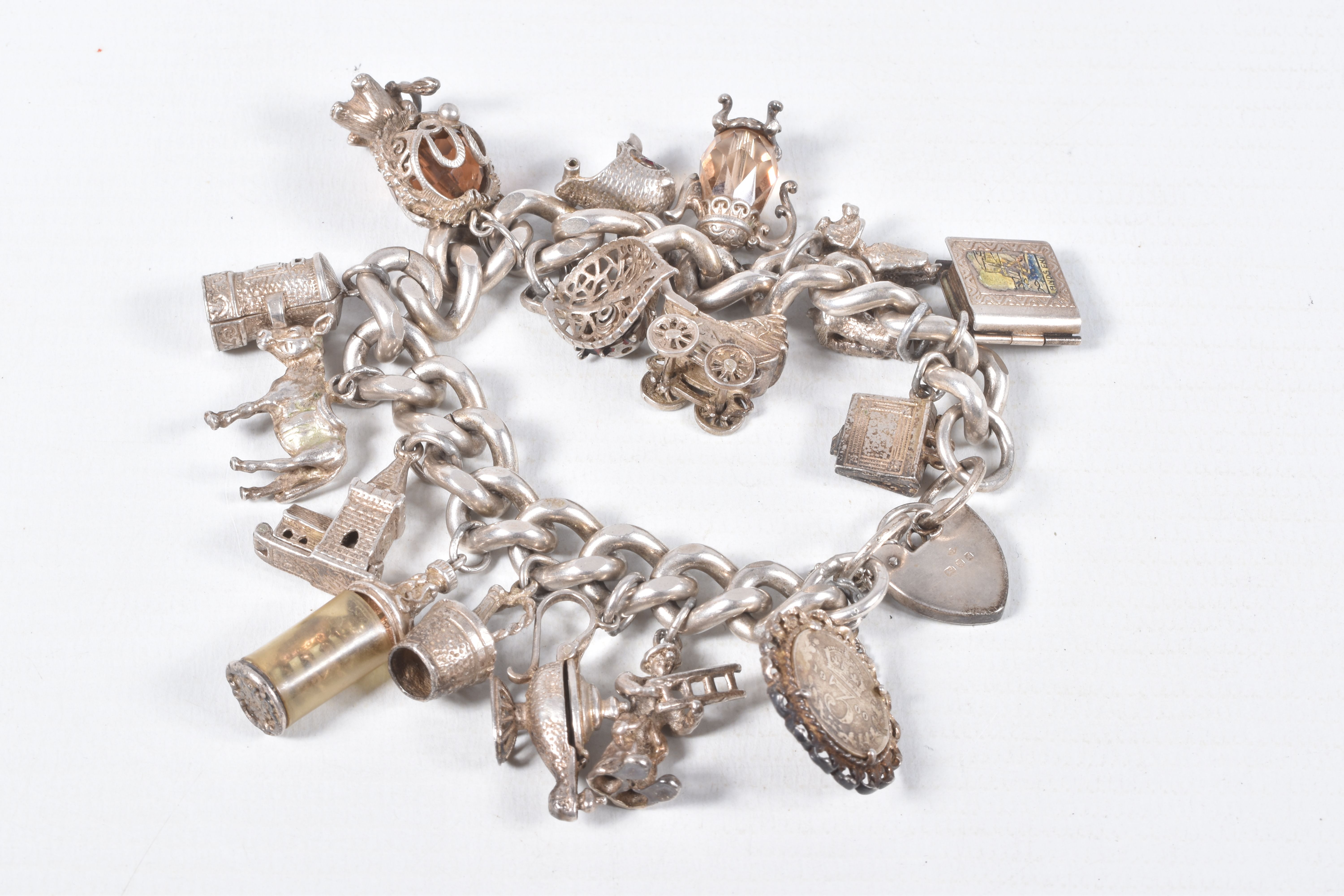 A SILVER CHARM BRACELET, a heavy curb link bracelet fitted with a heart padlock clasp, hallmarked '