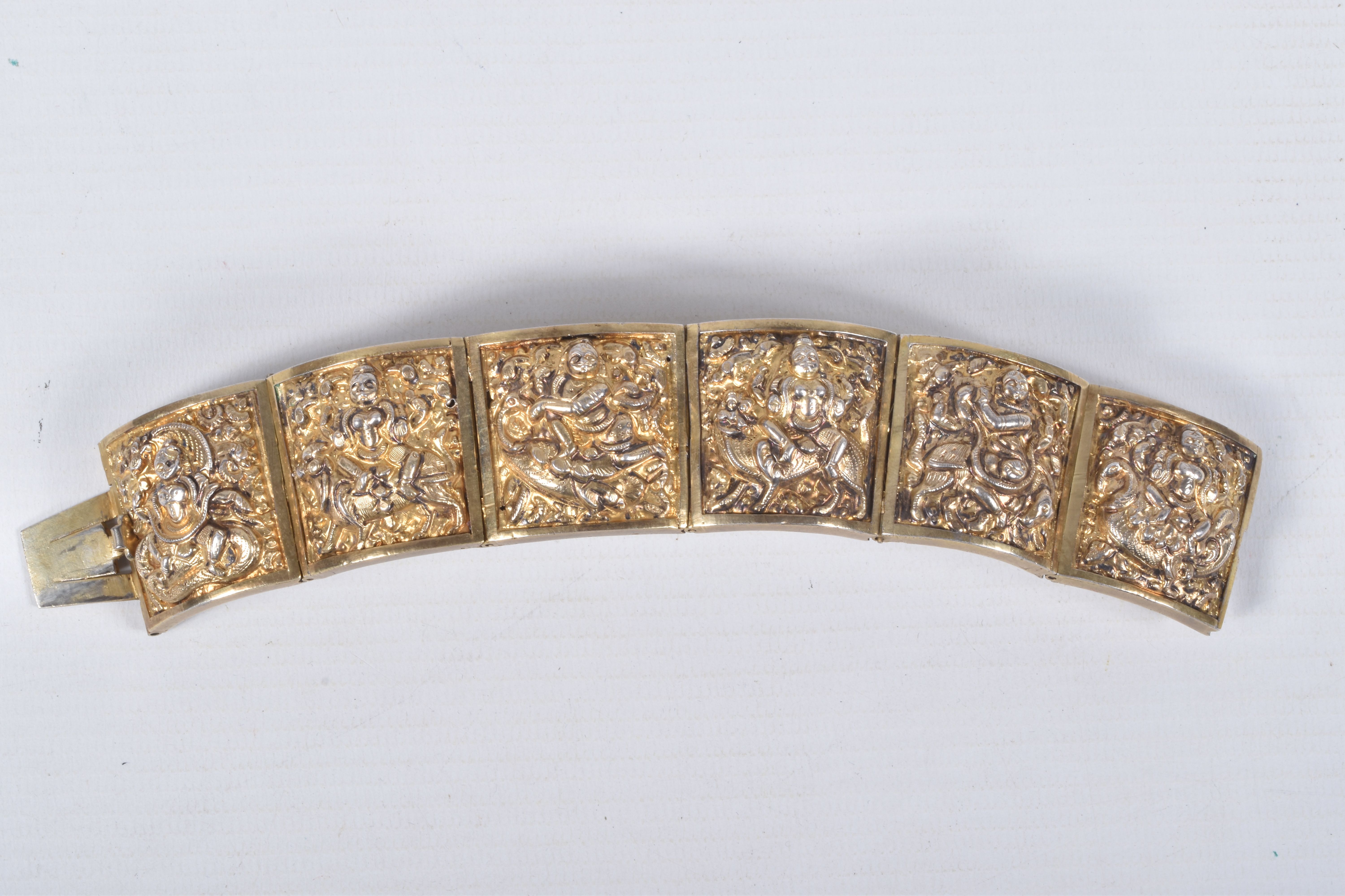 A VICTORIAN GILT BRACELET, comprised of six slightly tapered panels, embossed with an Indian design,