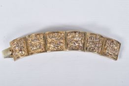 A VICTORIAN GILT BRACELET, comprised of six slightly tapered panels, embossed with an Indian design,