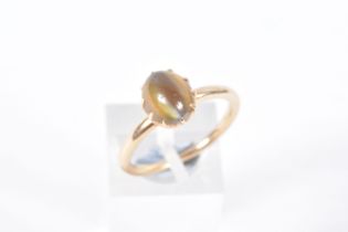 A YELLOW METAL CATS EYE CHRYSOBERYL RING, an oval cats eye chrysoberyl cabochon, approximate