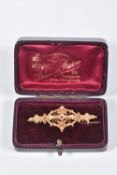 A BOXED 9CT GOLD BROOCH, open work brooch set with a small circular cut ruby and two small split