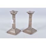 A PAIR OF LATE VICTORIAN SILVER CANDLE STICKS, Corinthian columns scroll leaf detail, on square