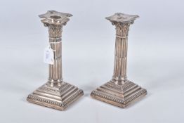 A PAIR OF LATE VICTORIAN SILVER CANDLE STICKS, Corinthian columns scroll leaf detail, on square