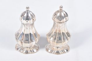 A PAIR OF EDWARDIAN SILVER PEPPERETTES, baluster form, on oval bases with pointed finial covers,