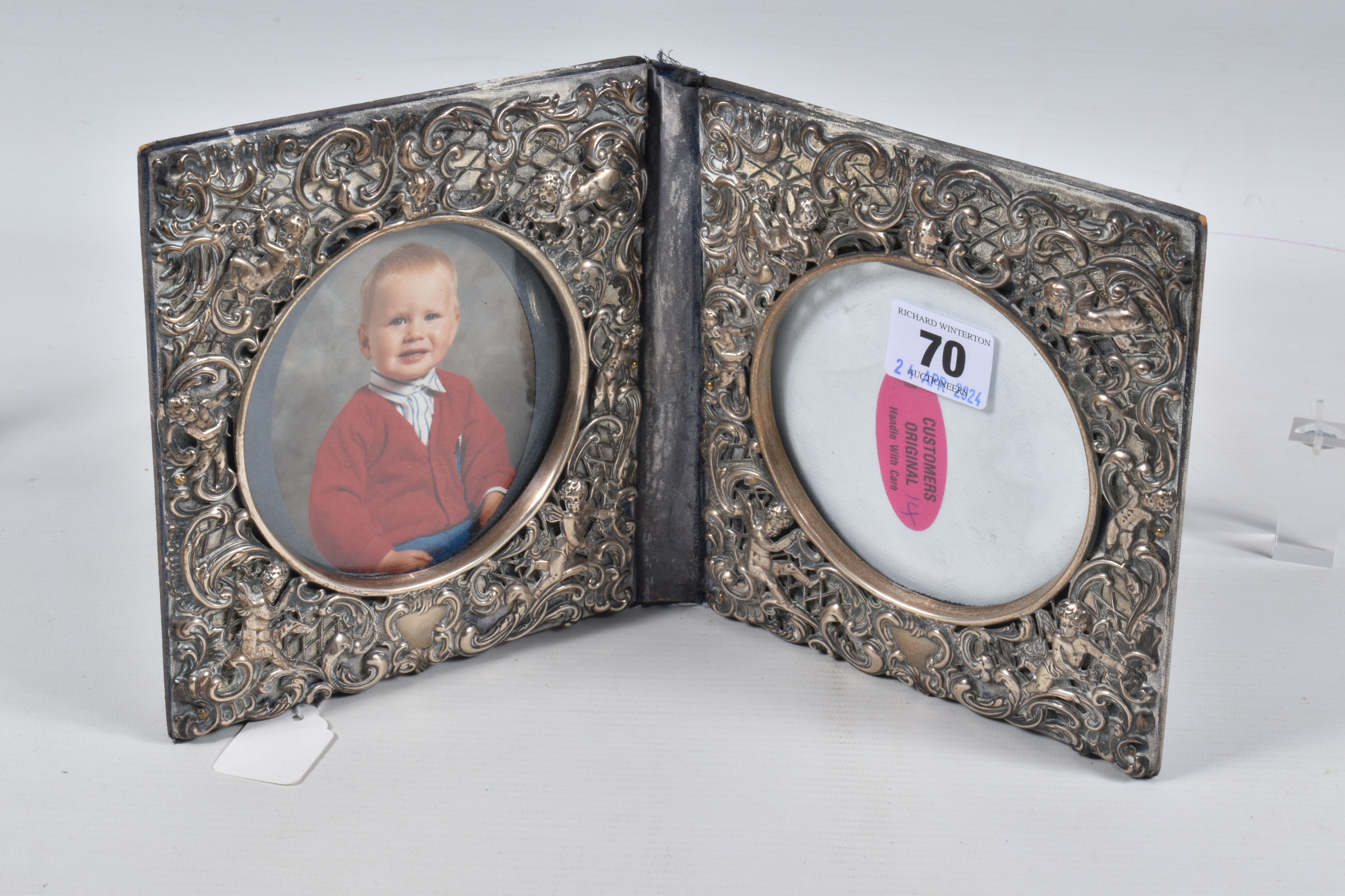 A DOUBLE PHOTO FRAME, white metal lined frame, with embossed foliate pattern with cherubs, folding - Image 2 of 3