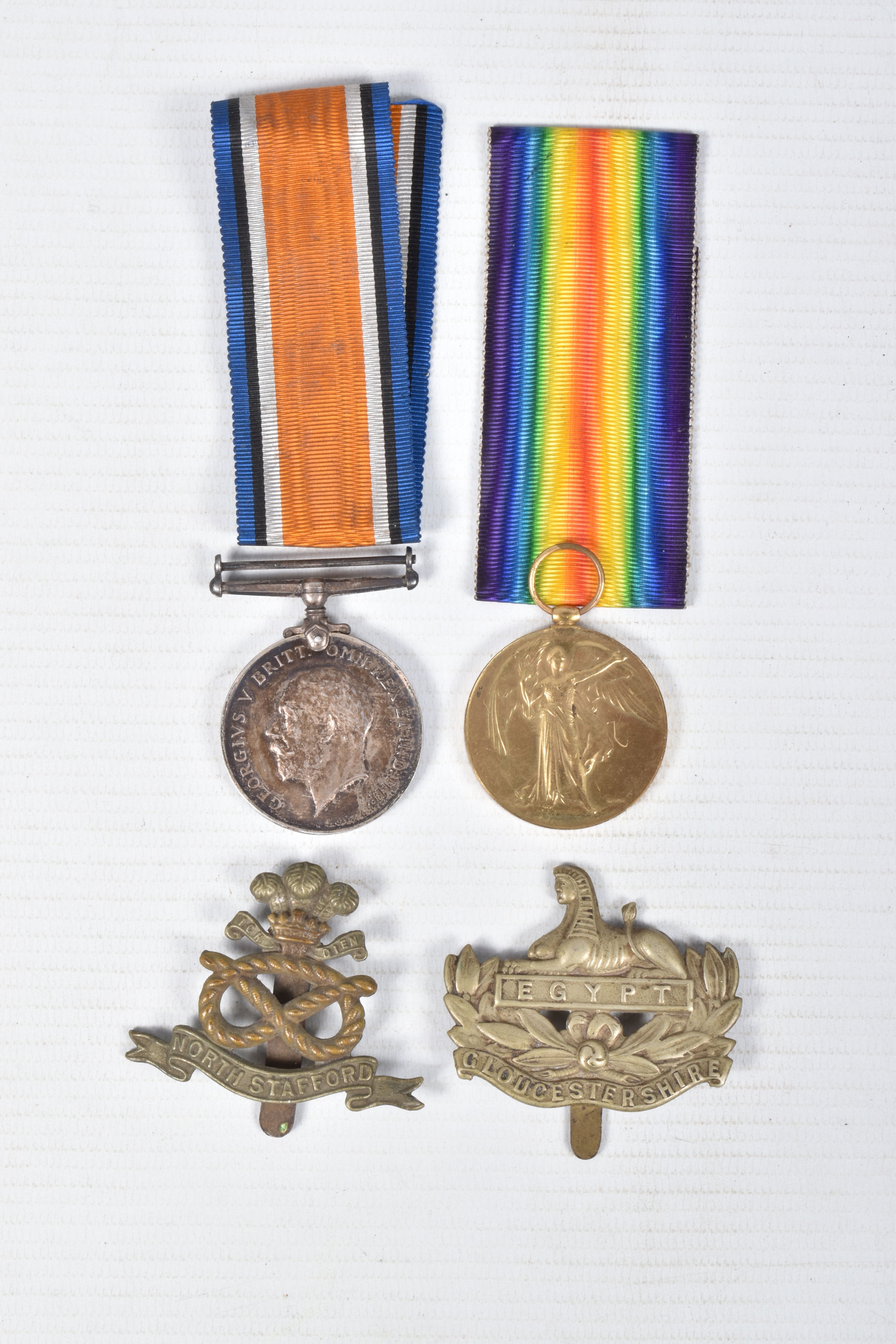 A WWI PAIR OF DURHAM LIGHT INFANTRY MEDALS AND TWO CAP BADGES, the medals are both correctly named