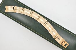A YELLOW METAL ARTICULATED BRACELET, designed as a series of eight rectangular, engine turned