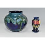 TWO MOORCROFT POTTERY VASES, comprising a 'Moonlit Blue' pattern vase, tube lined with green trees