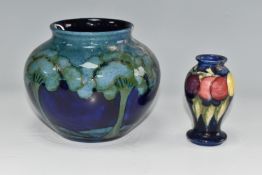 TWO MOORCROFT POTTERY VASES, comprising a 'Moonlit Blue' pattern vase, tube lined with green trees