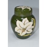 A MOORCROFT POTTERY GINGER JAR IN COVER DECORATED WITH WHITE LILIES ON A GREEN GROUND, faintly