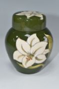 A MOORCROFT POTTERY GINGER JAR IN COVER DECORATED WITH WHITE LILIES ON A GREEN GROUND, faintly