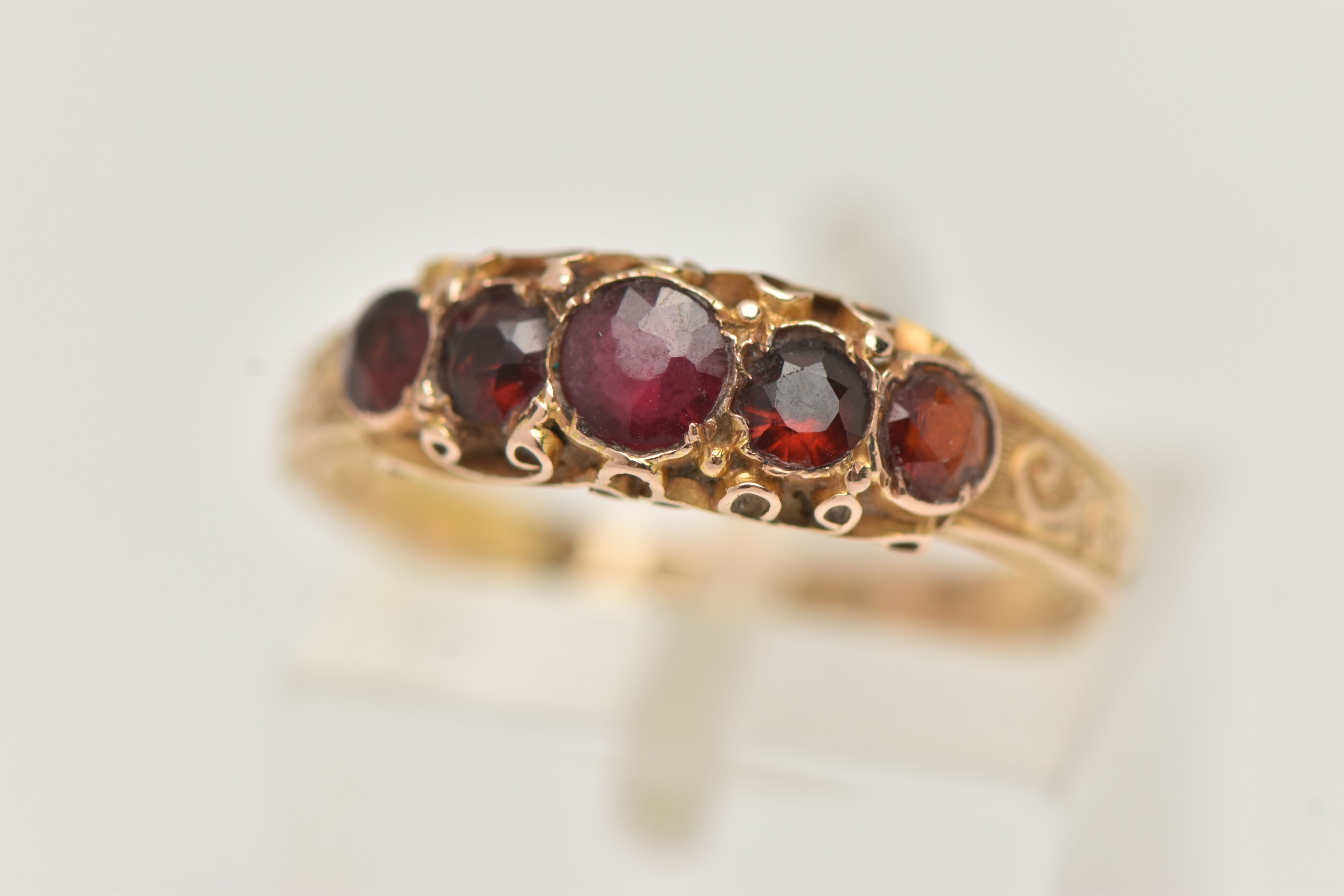 A 15CT GOLD MID VICTORIAN GARNET RING, five circular cut garnets set in yellow gold, scrolling