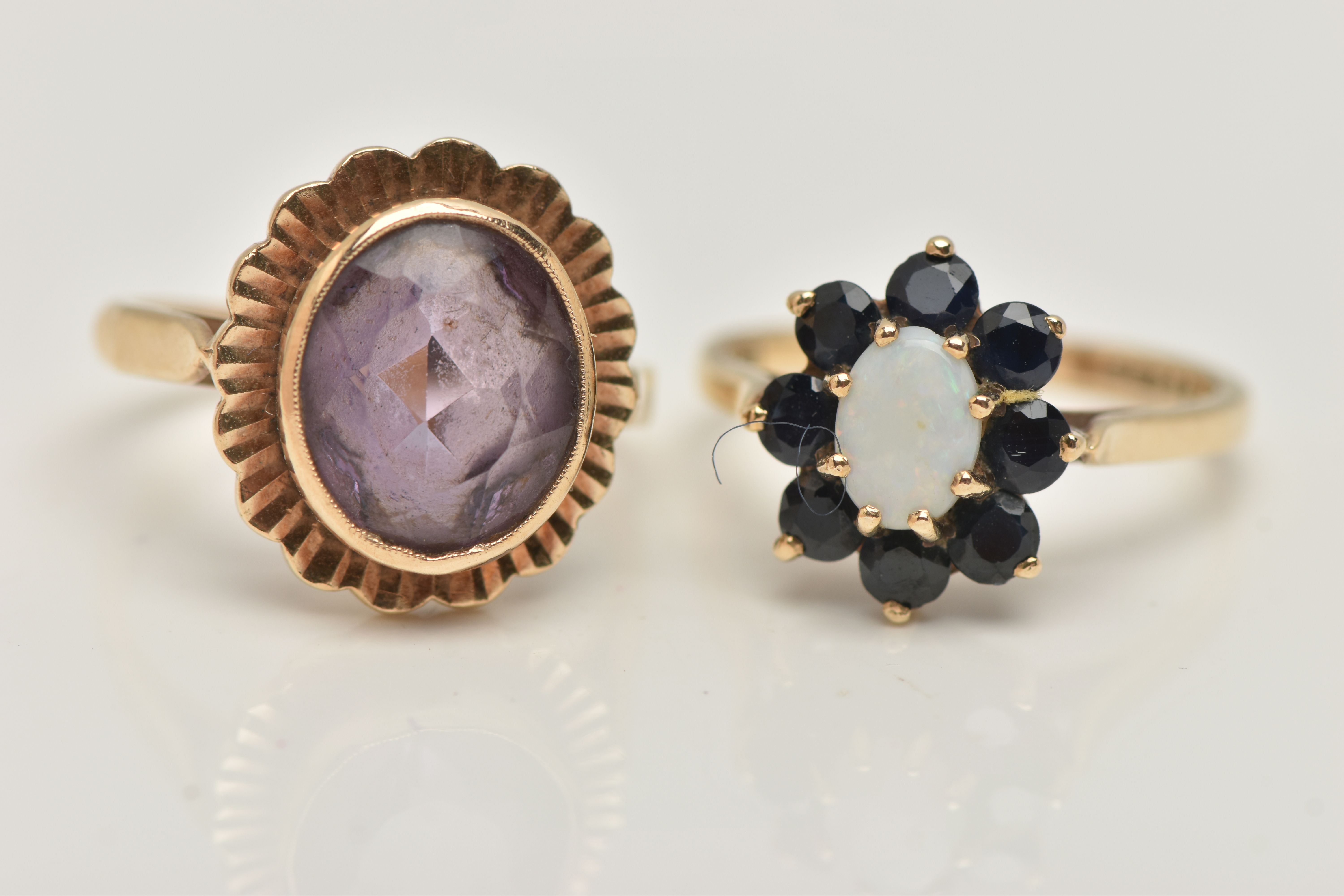 TWO GEM SET RINGS, the first an oval opal set with a surround of circular cut sapphires, prong set