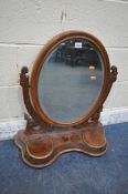 A VICTORIAN MAHOGANY TOILET MIRROR, the oval frame encasing a bevelled mirror plate, scrolled