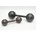 TWO VINTAGE CAST METAL DUMBELLS WITH SPHERICAL ENDS, the larger bears an impressed '6', the